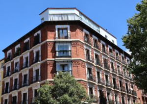 red brick apartment building blue sky and trees